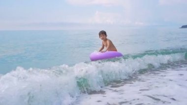 Şişme yüzük denizde yüzen çocuk