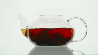 Bir cam çaydanlık beyaz arka planda siyah çay demleme