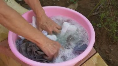 Eller eski kadın çamaşır giyim pembe bir plastik kapta