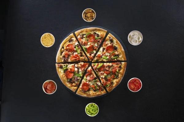 Düz İtalyan pizza ve çevresinde taze malzemelerle karanlık yüzey üstten görünüm üzerinde yatıyordu