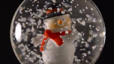 Kış kar küresi kardan adam içinde siyah arka plan ile