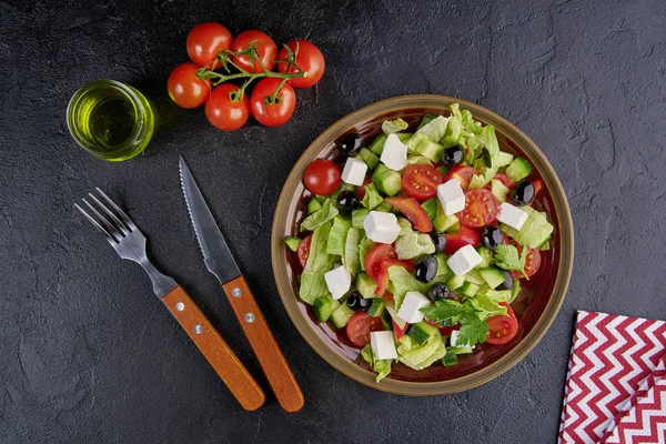 Salada grega com azeitonas e feta em fundo preto. Vista superior, flat lay — Fotografia de Stock