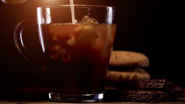 Café frio brew com gelo e leite no fundo preto — Vídeo de Stock