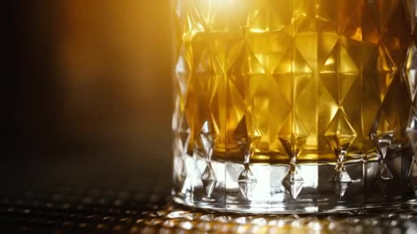 Whisky en las rocas en vidrio de la vieja moda con reflejos — Vídeos de Stock