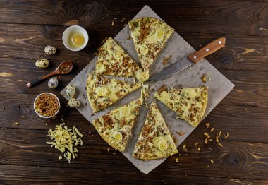 Ev yapımı pizza pişirme kağıdı ahşap arka plan üzerinde üstten görünüm üzerinde dilim kesilmiş,