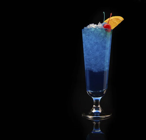 Тропічний синій коктейль з кюрасао, прикрашений свіжим апельсиновим шматочком та вишнями на чорному тлі — стокове фото