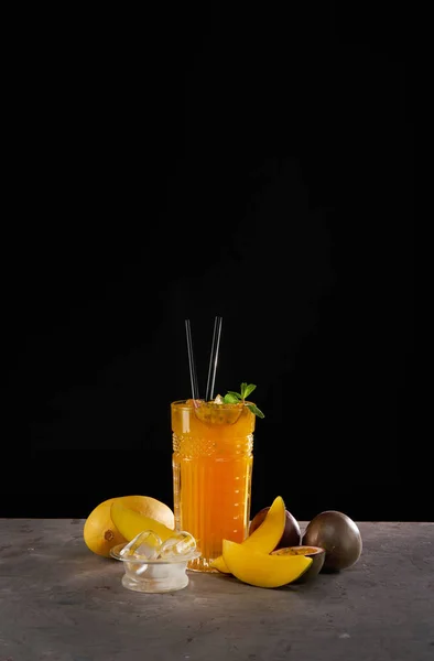 Fräsch cocktail med mango, mynta, passionsfrukt och is. Alkoholist, alkoholfri dryck-dryck på svart bakgrund — Stockfoto