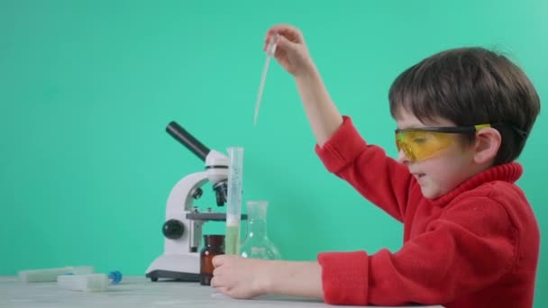 Kleiner Junge spielt mit chemischen Flüssigkeiten — Stockvideo