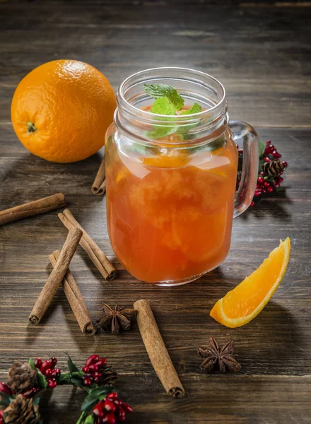 Orange coctail in the glass jar on wooden table with cinnamon — Stock Photo, Image