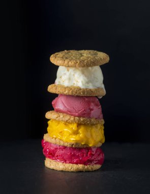 Siyah bir arka planda çerezleri ile renkli dondurma yığını