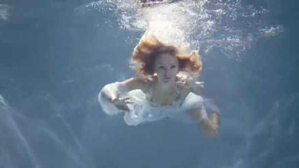 Jonge blonde vrouw in Vintage witte jurk zwemmen onderwater — Stockvideo