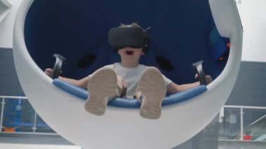 Hareketli interaktif sandalyede sanal gerçeklik kulaklı çocuk