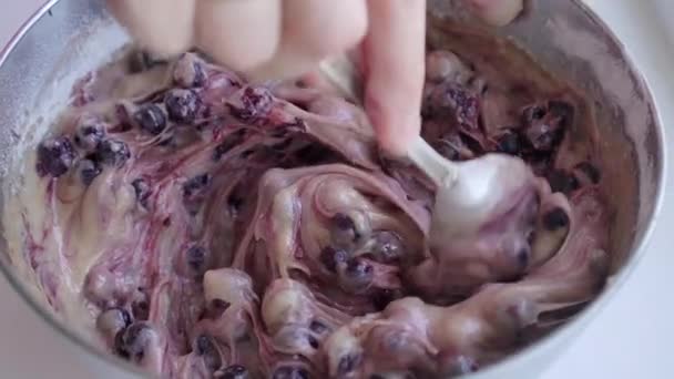 Vrouwelijke hand met lepel voorbereiding deeg voor blueberry pie in roestvrijstaal Bowl — Stockvideo