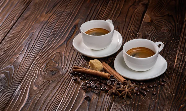 Zwei Tassen frisch gebrühten Espresso mit Kaffeebohnen auf einem rustikalen Holztisch — Stockfoto