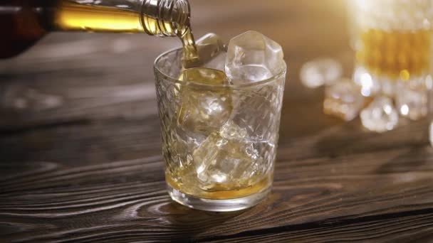 Whisky con hielo en una mesa de madera — Vídeos de Stock