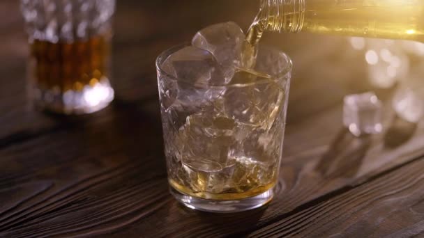 Barman nalewanie whisky z butelki do szkła na rustykalny drewniany stół — Wideo stockowe