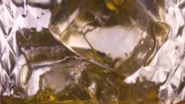 Yavaş çekimde buz küpleri ile cam scotch viski dökme