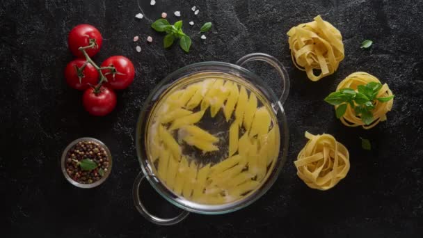 Cinemagraph-matlagning pasta penne i en glas gryta med kokande vatten — Stockvideo