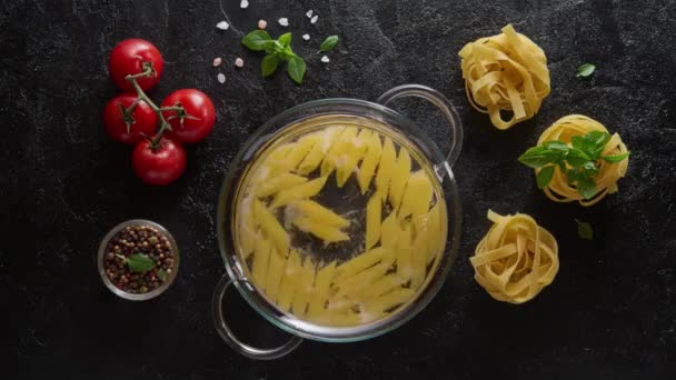 Cinemagraph - cuisson des pâtes penne dans une casserole en verre avec de l'eau bouillante — Video