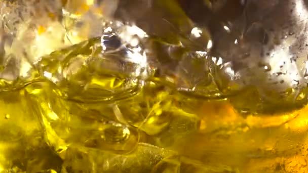 Hälla Scotch Whisky i glas med isbitar i slow motion — Stockvideo