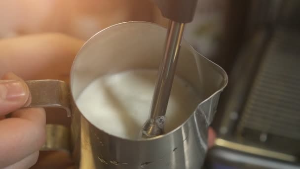 Парящее и пенящееся молоко бариста в стальном стальном барабане с кофеваркой эспрессо для капучино или латте — стоковое видео