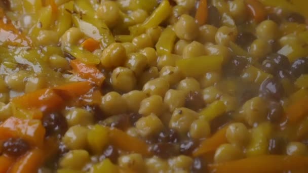 Verduras guisadas en una sartén cocinando platos vegetarianos de garbanzos . — Vídeo de stock