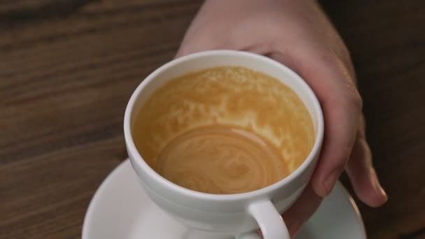 Barista gieten melk in de kop koffie maken van een patroon — Stockvideo