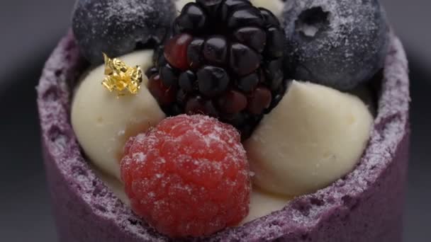 Delicioso pastel con mousse de mora y arándano sobre fondo negro — Vídeos de Stock