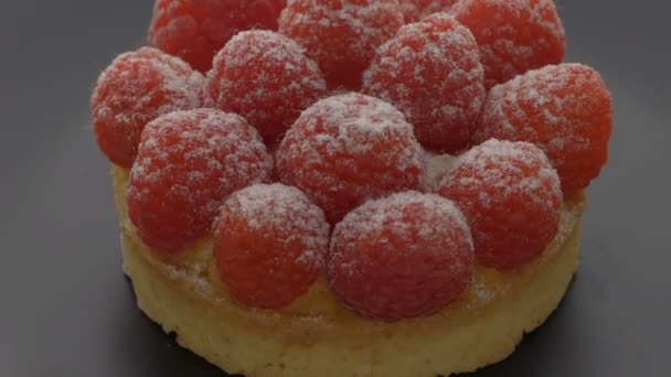 Sweet tartlet with raspberries rotating on gray background — Stock Video