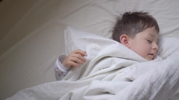 Evde yatakta germe sevimli küçük çocuk üst görünümü — Stok video