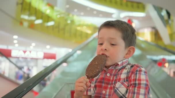 Niño feliz en el carrito de compras con sabroso helado durante las compras familiares en el hipermercado — Vídeos de Stock