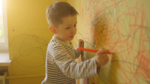 Μικρό αγόρι που ζωγραφίζει στον κίτρινο τοίχο στο σπίτι — Αρχείο Βίντεο