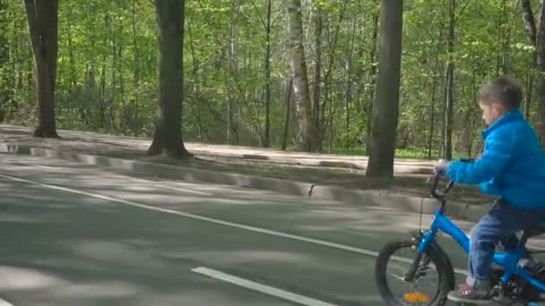 Happy Boy op een fiets op asfalt weg. Leuke jongen leren fietsen op een fiets baan. — Stockvideo