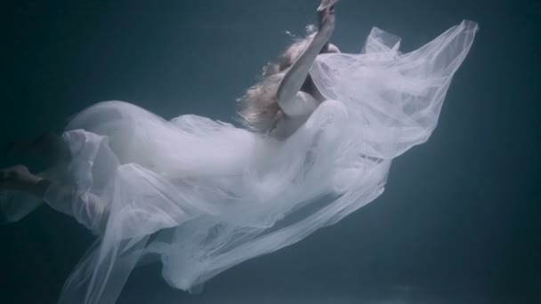Giovane bella donna in abito bianco nuotare sott'acqua — Video Stock