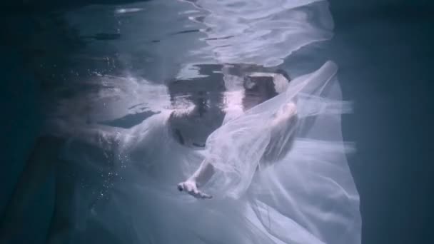 Hermosa mujer nadando bajo el agua en vestido elegante blanco — Vídeos de Stock