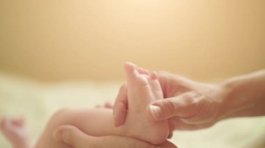 Anne, çocuklarına ayak masajı yaparak yatakta