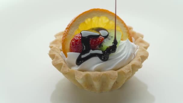 Свежий фруктовый пирог с клубникой, апельсином, киви и шоколадным соусом — стоковое видео