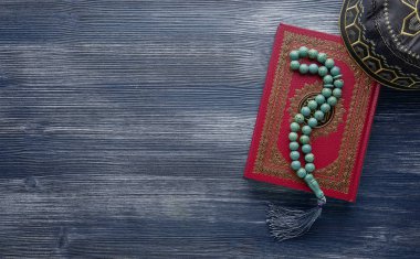 Ahşap arka planda tespih boncuklu İslam Kuran. Kopyalama alanı ile İslami kavram