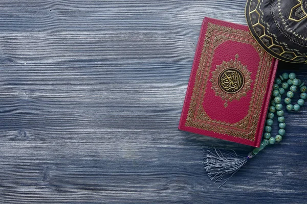 Corán con cuentas de rosario sobre fondo de madera. Concepto islámico con espacio de copia — Foto de Stock