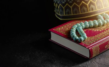 Müslümanlar için tespih boncuk ve kopiah şapka ile Kur'an-ı Kerim