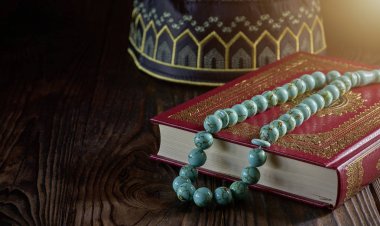 Tahta masa üzerinde müslümanlar için tespih boncuk ve kopiah şapka ile İslam kitap Kuran