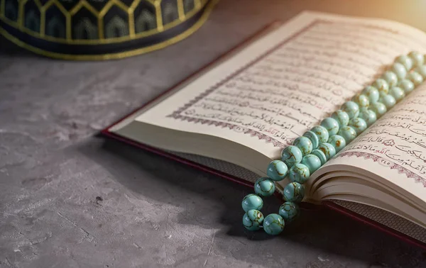 Libro islámico Corán con cuentas de rosario y sombrero de oración para los musulmanes sobre fondo gris — Foto de Stock