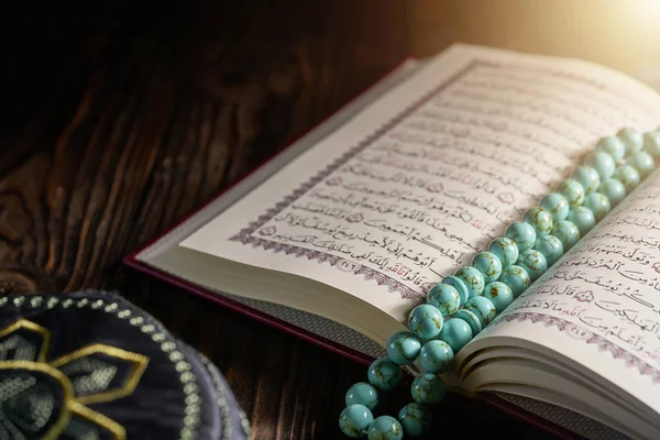 Corán islámico con cuentas de rosario y sombrero kopiah para musulmanes en mesa de madera — Foto de Stock