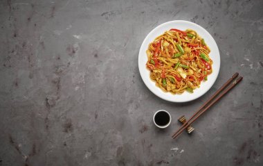 Gri taş arka planda sığır ve sebze ile Çin noodle. Üstteki görünüm, kopya alanı