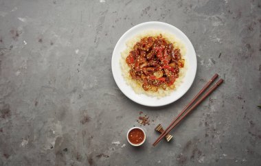 Gri taş arka planda sebze ve pirinç ile tatlı ve ekşi kızarmış domuz parçaları. Kopya alanı ile üst görünüm