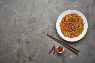 Gri taş arka planda sığır ve sebze ile soba noodle. Üstteki görünüm, kopya alanı