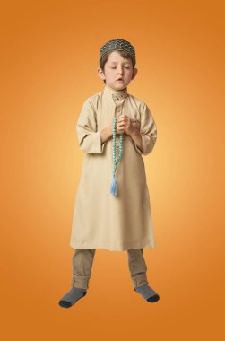 Küçük Müslüman çocuk dua ve renkli arka plan üzerinde dua boncuk tutan