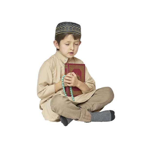 Niño musulmán rezando y sosteniendo el Corán con cuentas de rosario sobre fondo blanco — Foto de Stock