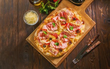 Koyu ahşap bir masada jambon ile gözleme pizza üst görünümü