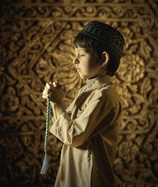 Kleiner muslimischer Junge mit Rosenkranzperlen, der zu Gott betet — Stockfoto
